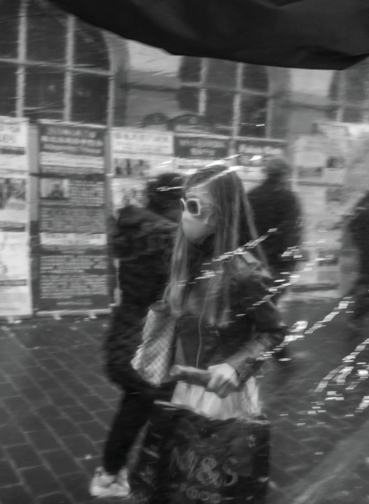 A stylish young woman seen as a soft reflection in a London café or restaurant window.