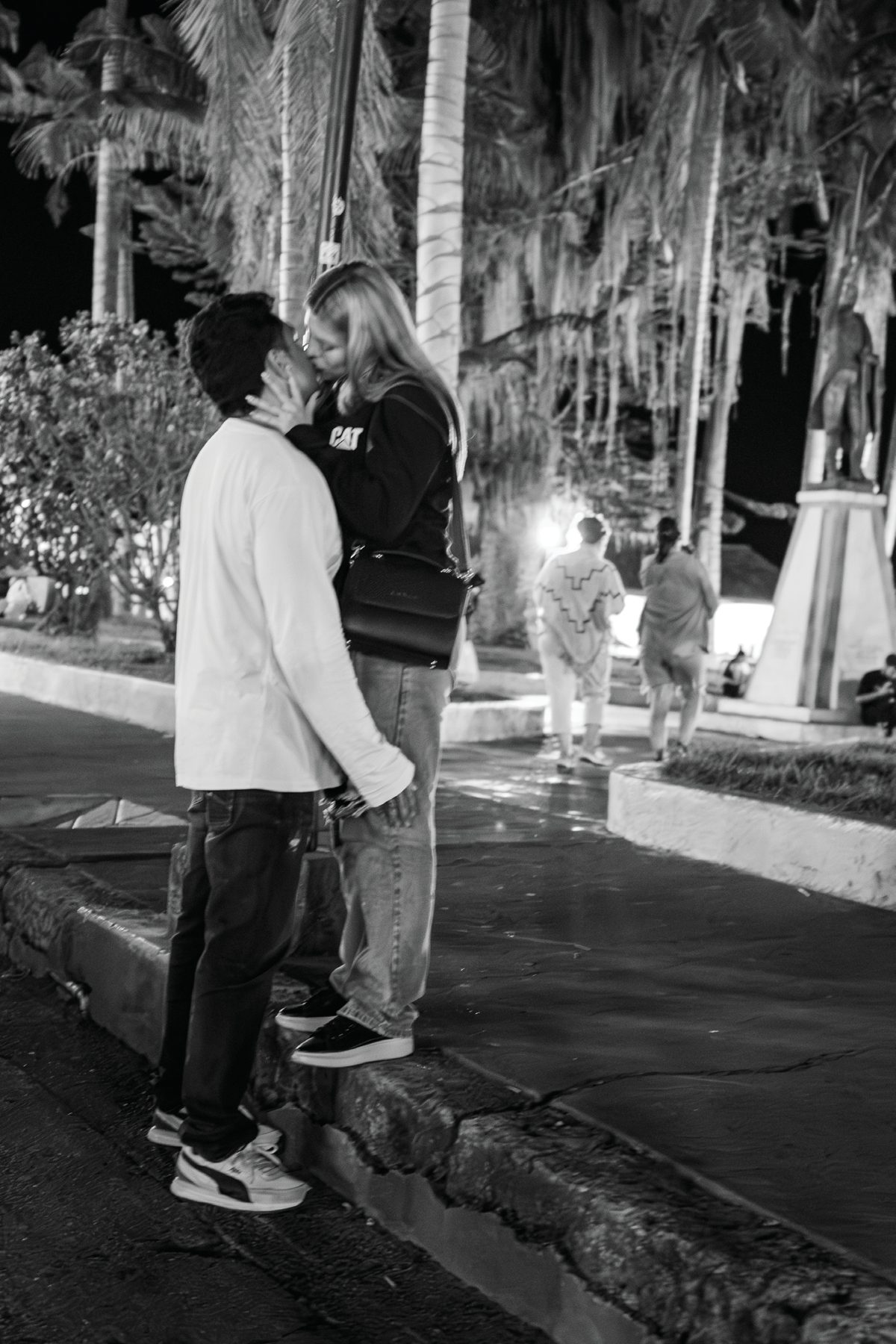 A young couple standing close together on a nighttime street in Salento, Colombia.