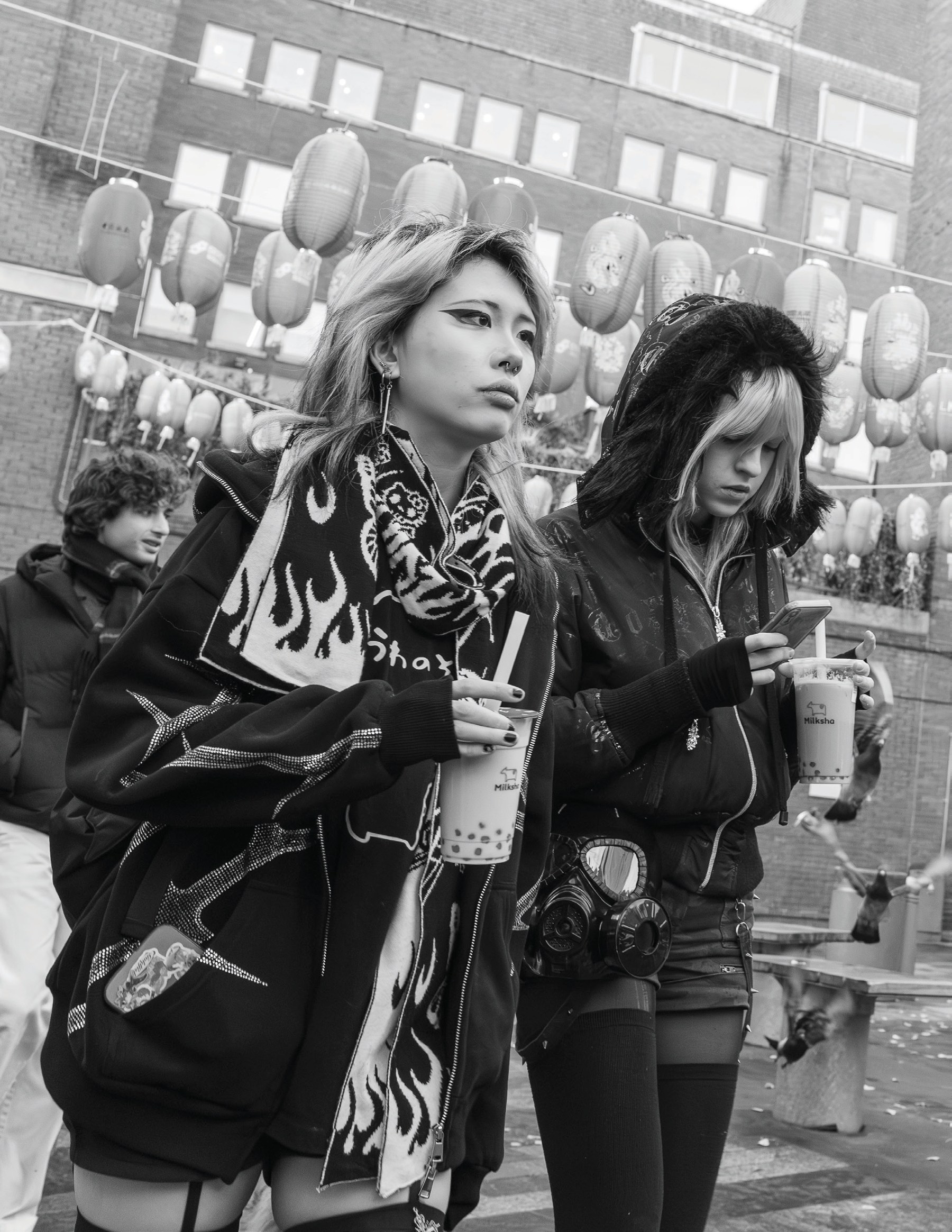 Two young women standing in London’s Chinatown, one carrying a distinctive gas-mask-shaped purse.