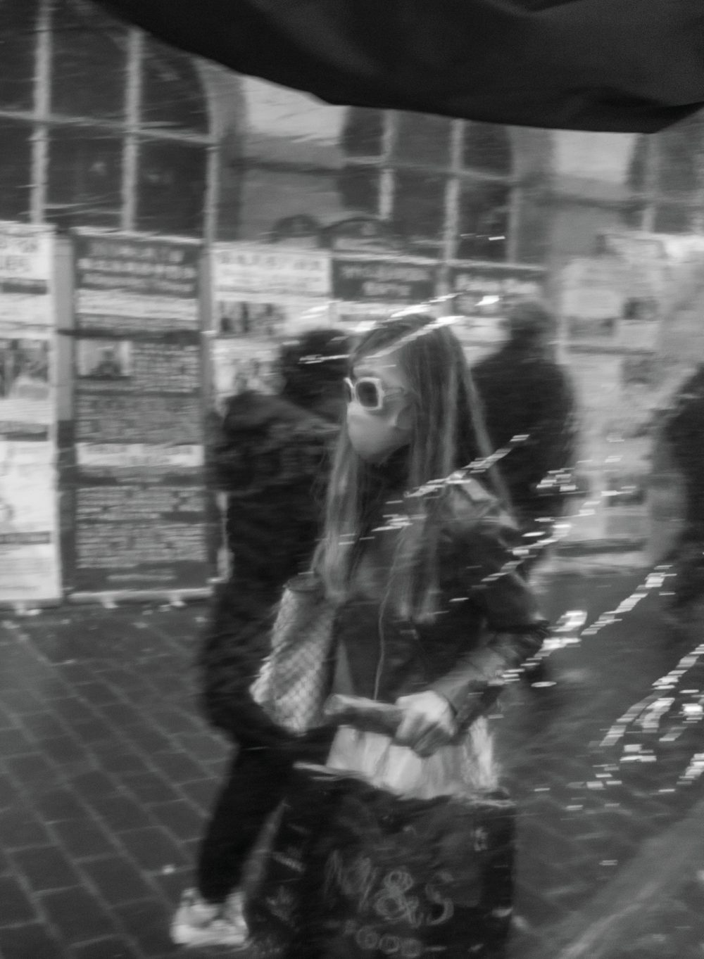 A stylish young woman seen as a soft reflection in a London café or restaurant window.