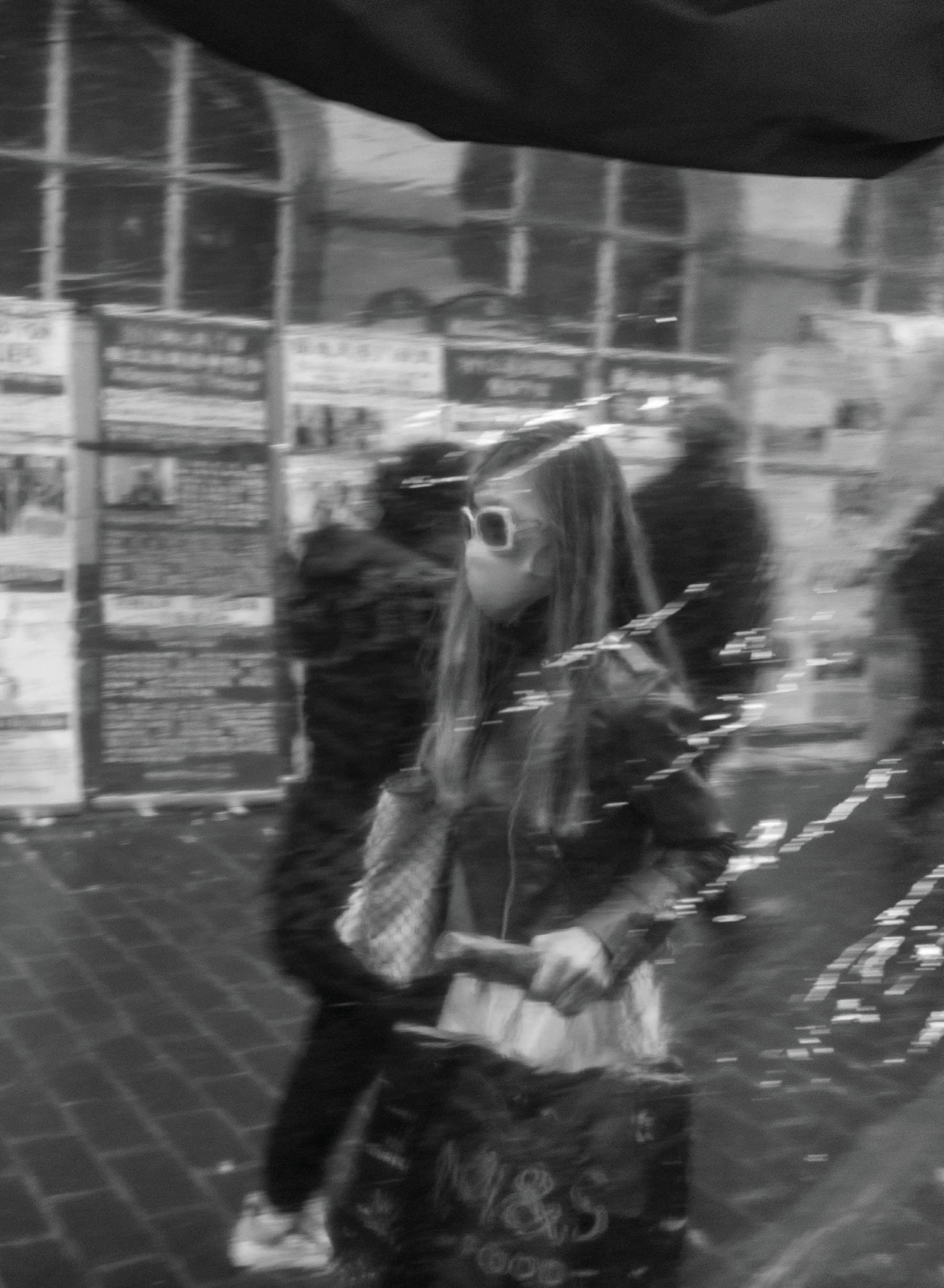 A stylish young woman seen as a soft reflection in a London café or restaurant window.