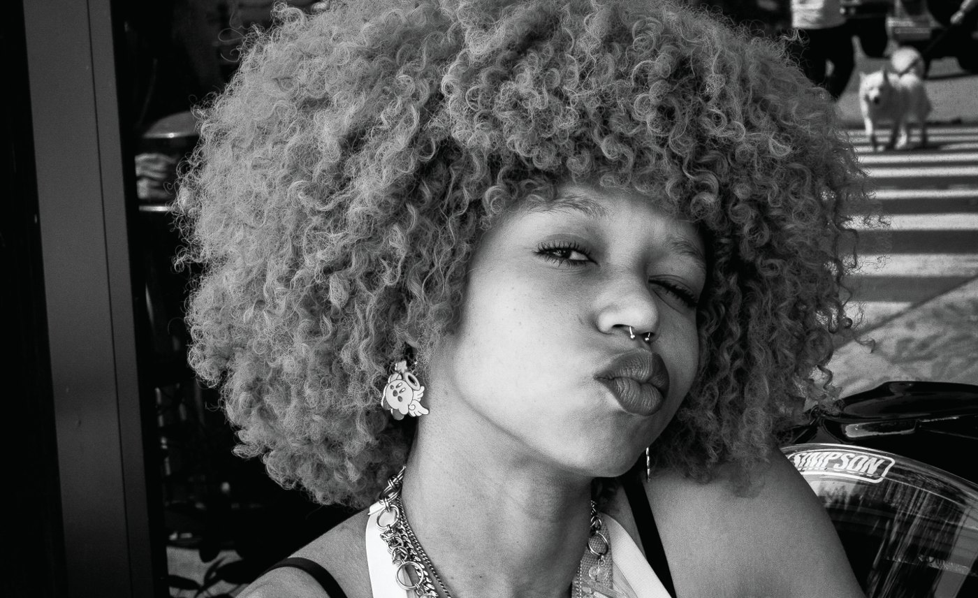 A woman named Panther making a playful expression toward the camera at a Los Angeles street café.