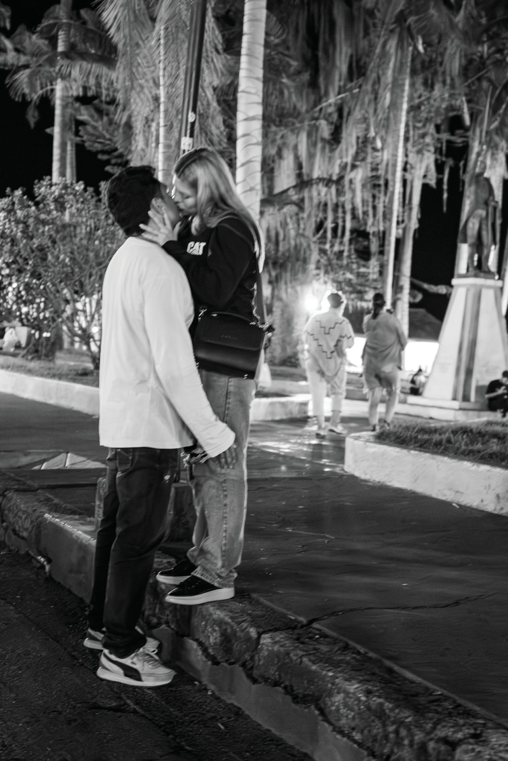 A young couple standing close together on a nighttime street in Salento, Colombia.